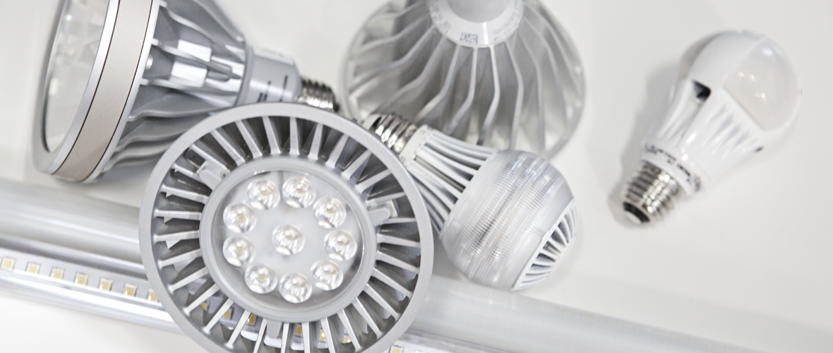 Five different types of lightbulbs sitting on a white table