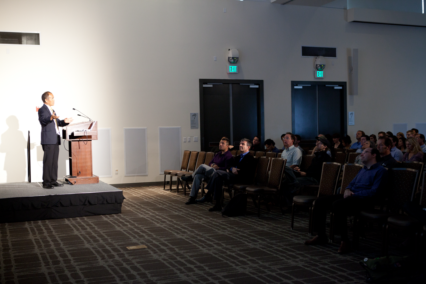Aumann Lecture 4 - (A person at a podium standing talking to a group of people)