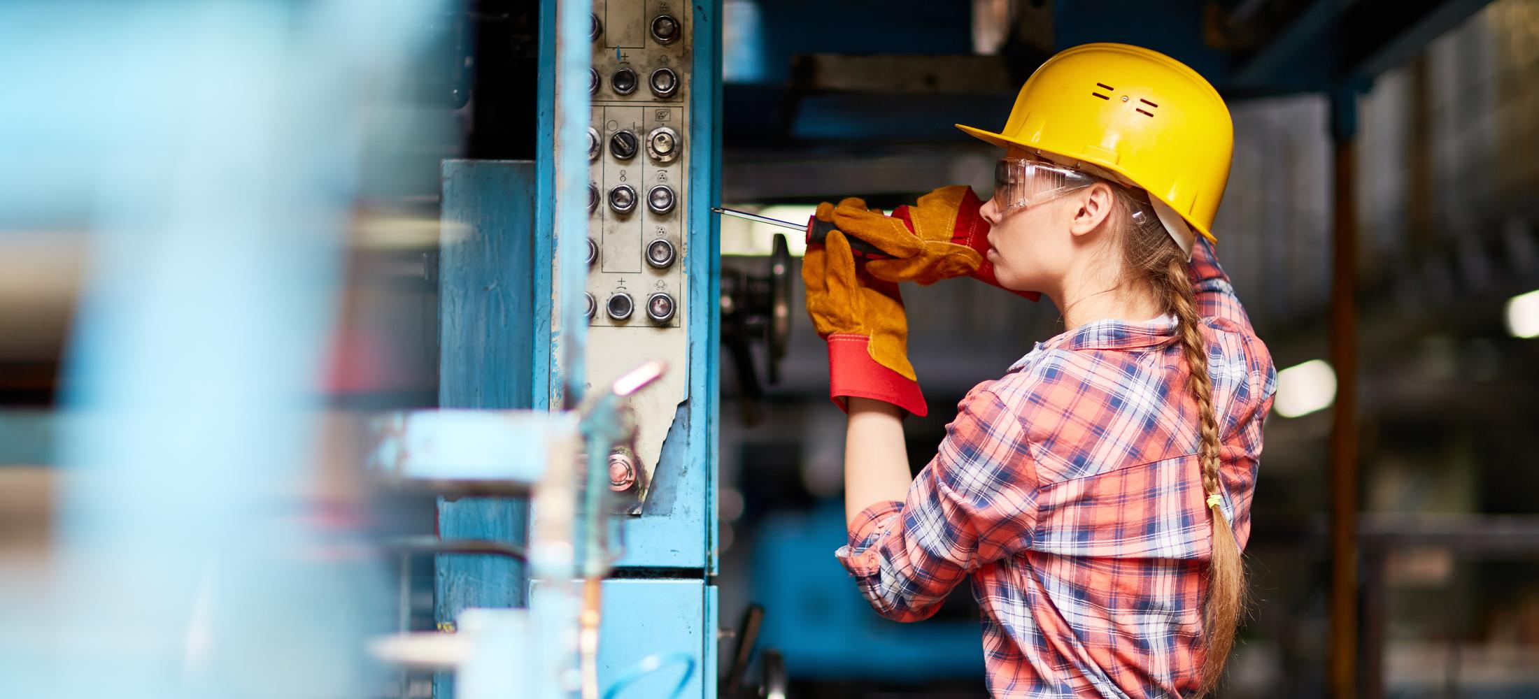 Electrician with hardhat working on an electrical panel