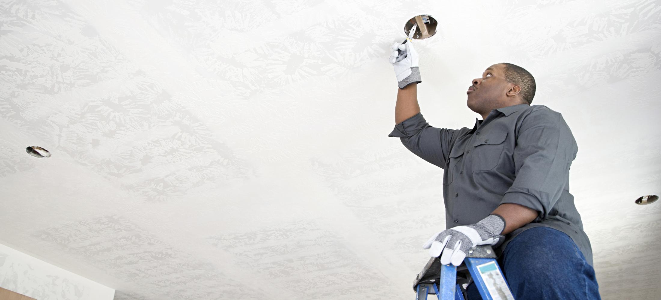 Electrician working on ceiling light