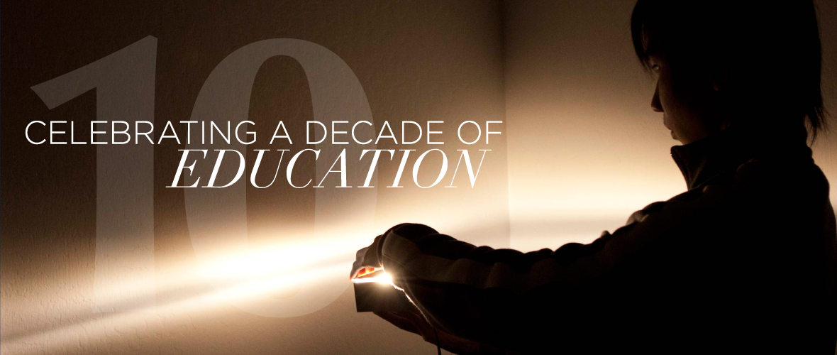 Celebrating a decade of education (An image of a person's silhouette holding a light with the light radiating in a horizontal line)