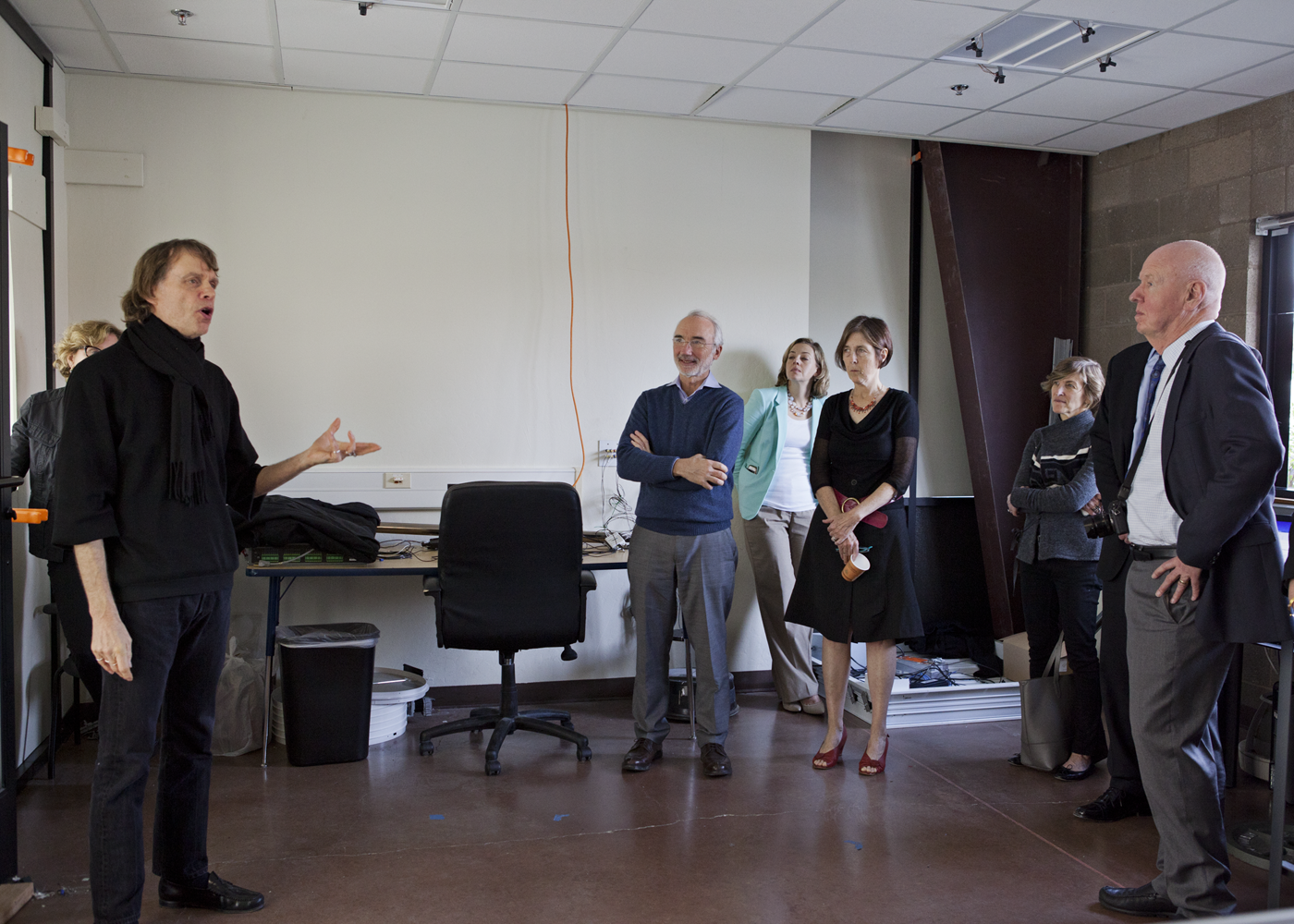 Michael Siminovitch standing and talking in front of a group of five people