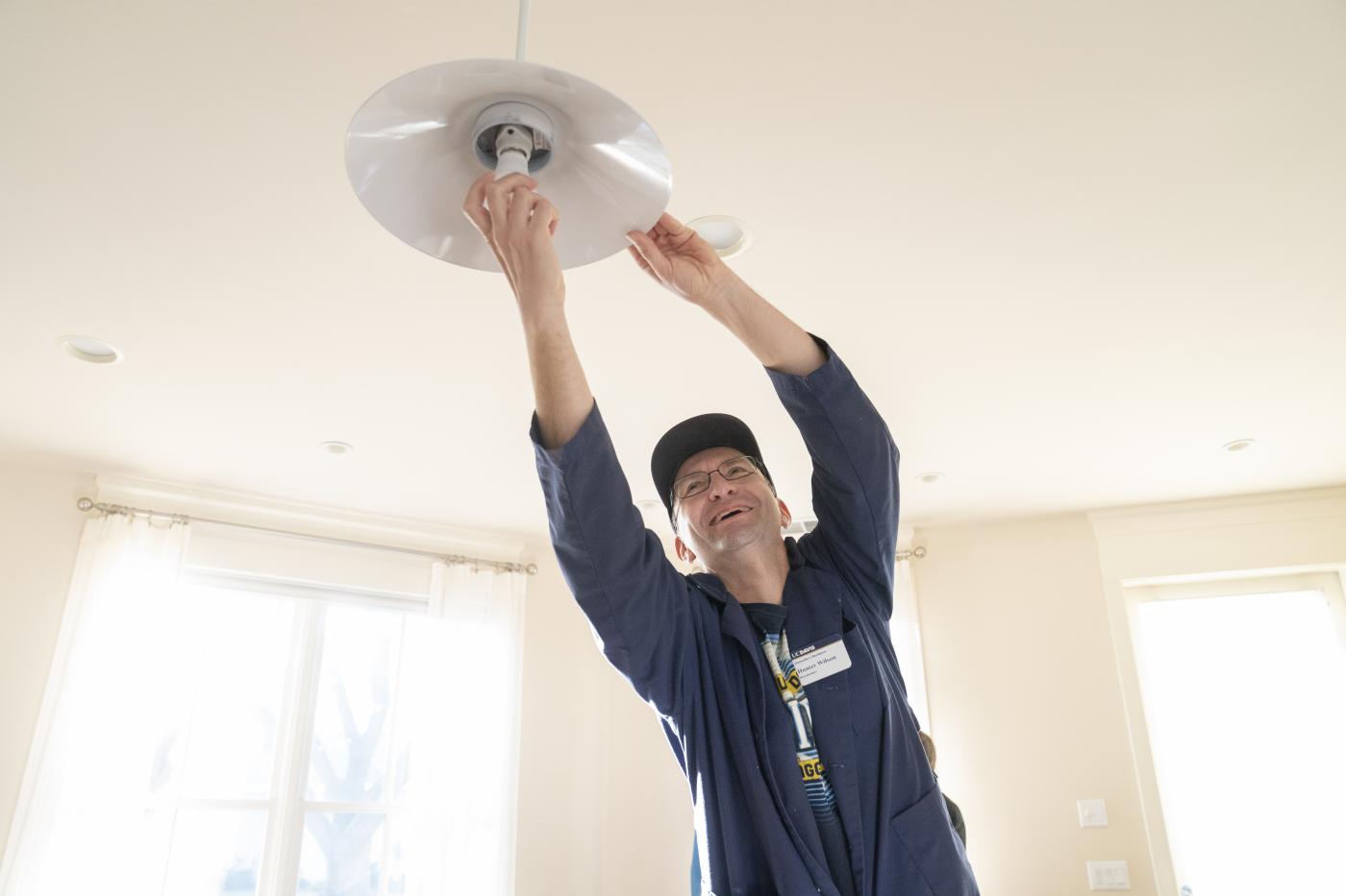 A UC Davis employee changing a light bulb