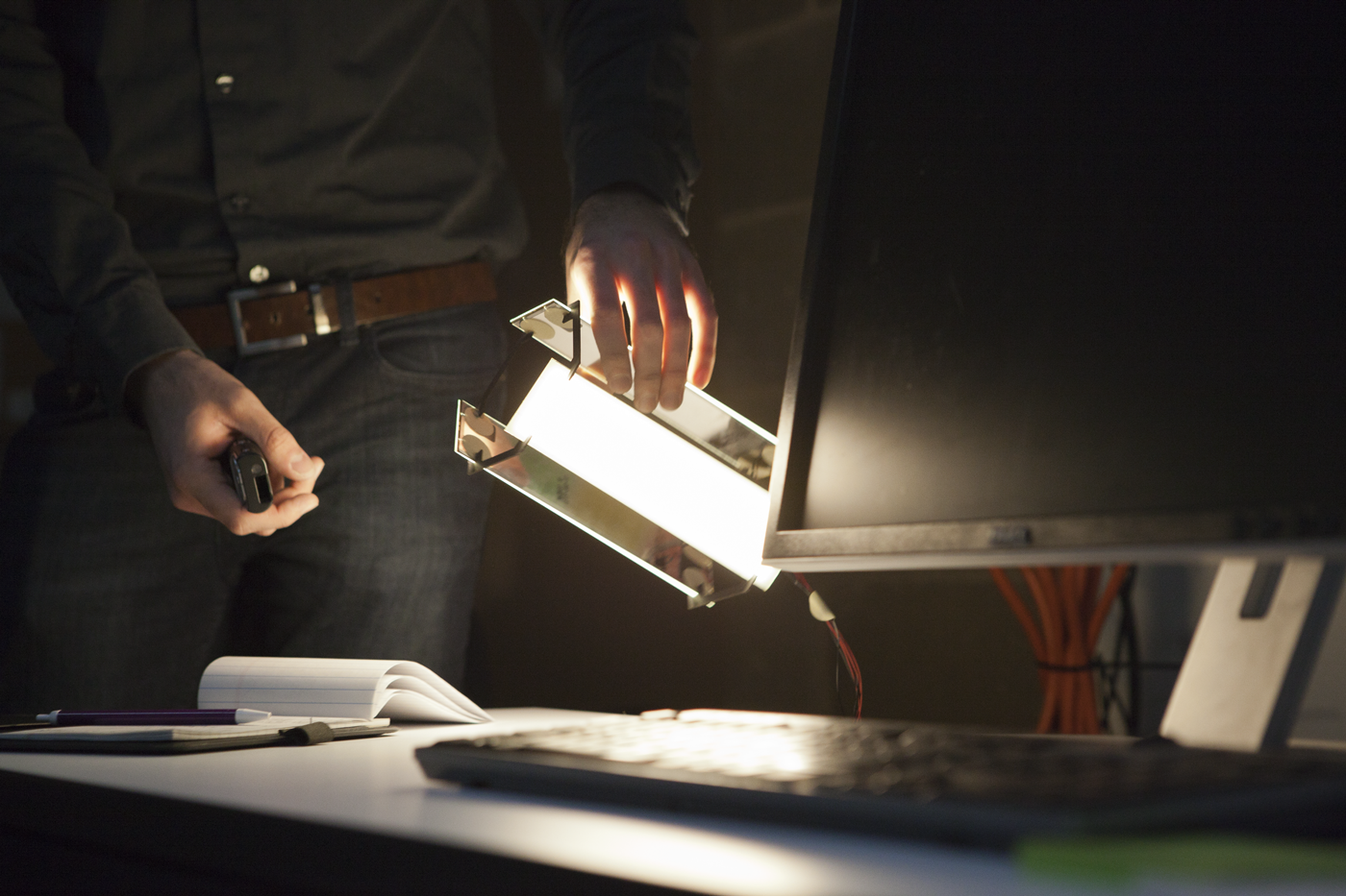 Close up of a person holding a light fixture they are working on building