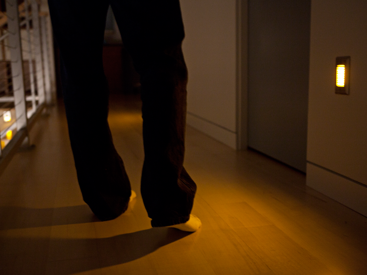Close up of a persons feet while walking in amber lighting