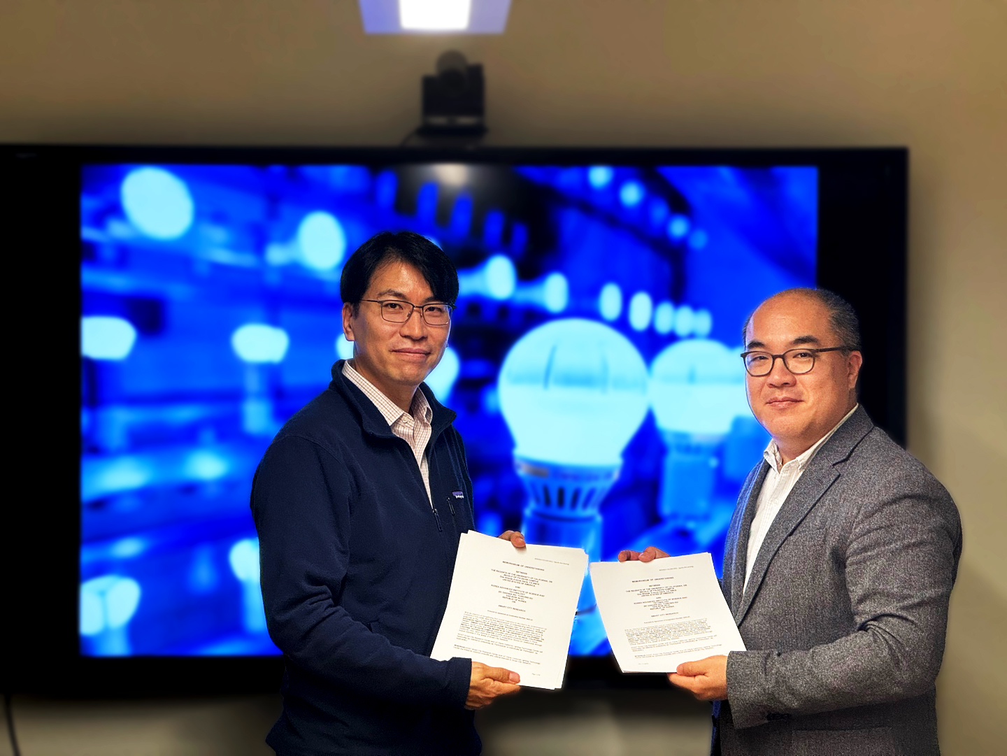 Professor Jae Yong Suk of CLTC and Professor Youngchul Kim of KAIST showing copies of an MOU