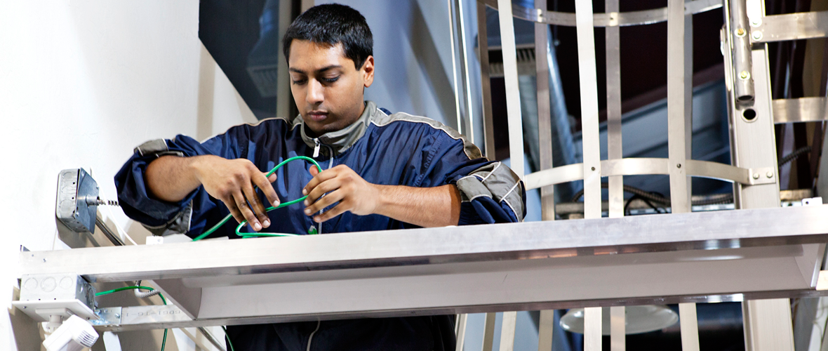 A person standing and working with electrical wires
