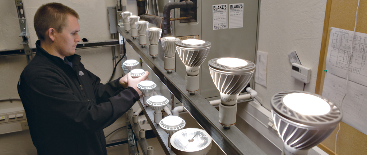 Person putting a light bulb into a row with multiple light bulbs