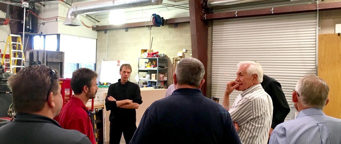 Group of seven people standing around and having a discussion