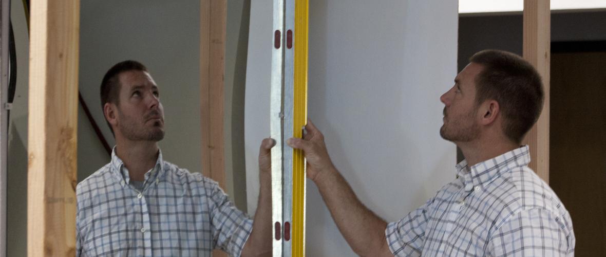 Person standing in front of a mirror and measuring the sides
