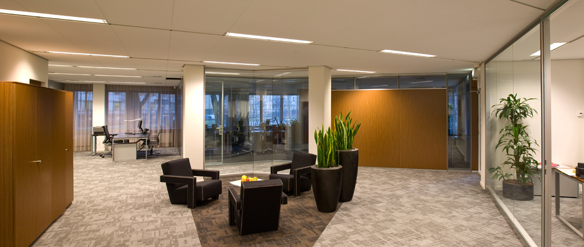 Interior of an office space with three couches and glass doors separating the office rooms