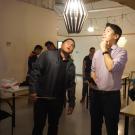 Jae and another person looking at a light fixture hanging from the ceiling
